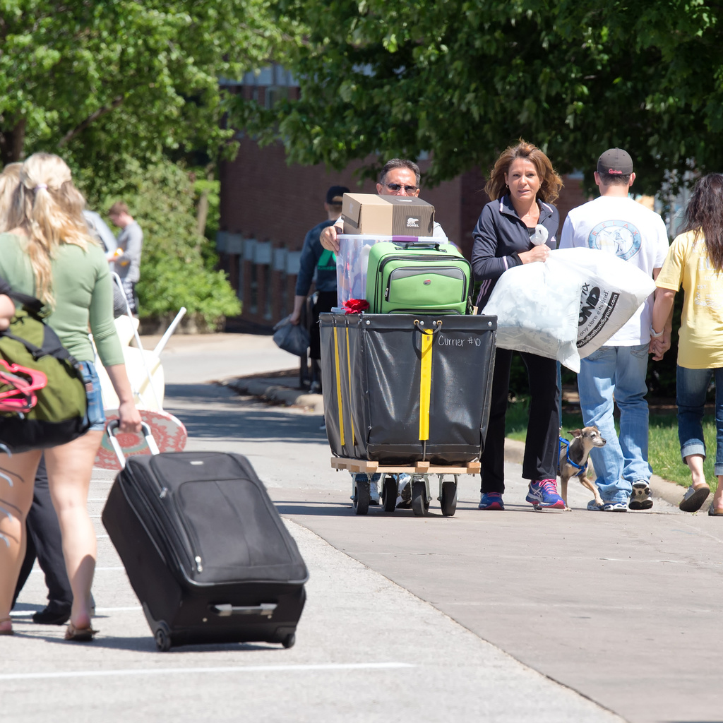parents and student moving into dorm room