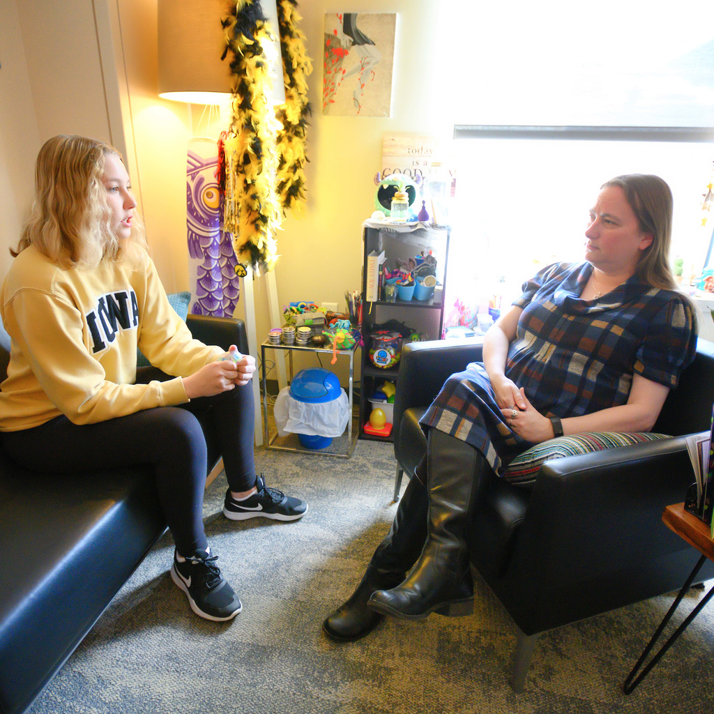 therapist sits with patient in room